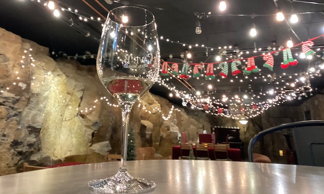 Glass of Cave B wine in the candle-lit tasting cave